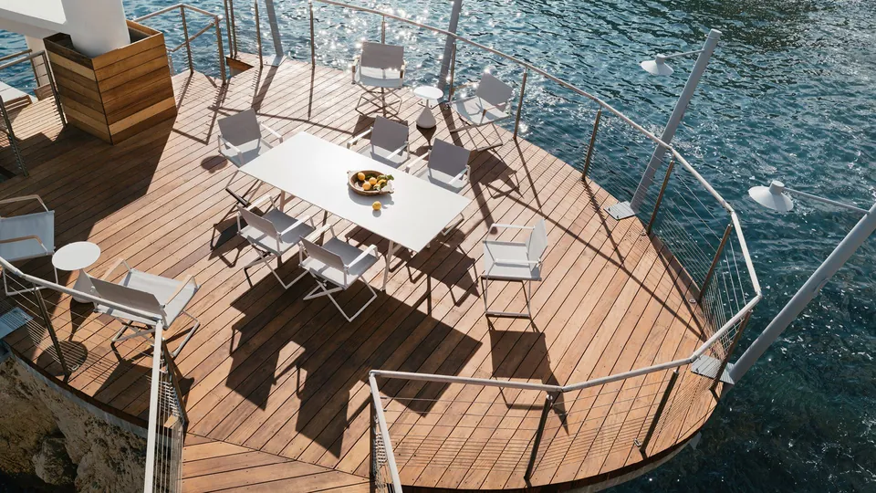 Dedon outdoor dining set on a patio, woven dining chairs around an outdoor table